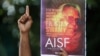 A man gestures as he holds a placard during a protest to show solidarity with a Christian priest and an activist Father Stanislaus Lourduswamy, Mumbai, India, July 7, 2021.