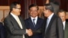 Cambodian Prime Minister Hun Sen, second from right, shakes hands with the main opposition party leader Sam Rainsy, left, of Cambodia National Rescue Party, as Deputy Prime Minister Sar Kheng, second from left, looks on after a meeting in Senate headquarters, Phnom Penh, Cambodia, July 22, 2017)