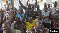 Supporters of presidential candidate Muhammadu Buhari cheer as they watch news coverage of election results favourable to them on a street in Lagos, March 31, 2015. The opposition All Progressives Congress (APC) declared victory for its candidate, former 