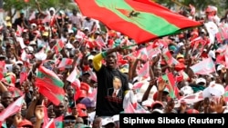 Apoiante da UNITA, em comício do partido, ergue bandeira com Isaías Samakuva