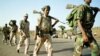 Eritrean soldiers march past displaced civilians as they redeploy near the town of Adi Quala on June 2.