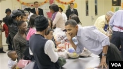 Presiden Amerika Barack Obama, mendengarkan seorang anak selagi memmbantu dalam acara Thanksgiving di Martha's Table, sebuah toko makanan di Washington.