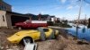 FILE - A Corvette and a truck flooded by the storm surge of Superstorm Sandy in Lindenhurst, New York.