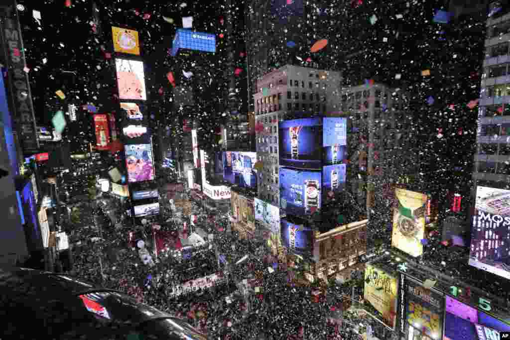 Confetti drops over the crowd as the clock strikes midnight during the New Year&#39;s celebration in Times Square as seen from the Marriott Marquis in New York, Monday, Jan. 1, 2018. (AP Photo/Seth Wenig)