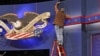 A worker cleans lint off the background of the stage for a debate at the University of Denver ,Tuesday, Oct. 2, 2012, in Denver. President Barack Obama and Republican presidential candidate and former Massachusetts Gov. Mitt Romney will hold their first d