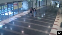 华盛顿都会区机场管理局公布的照片显示12岁的马金晶(译音）2018年8月2日与一名女子走过里根国家机场的“行李/抵达”楼层。在马金晶第二天被发现在纽约与父母在一起之前，当局将她的失踪视为儿童绑架案并展开了紧急搜寻。