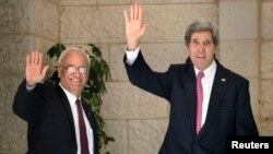 Menlu Amerika John Kerry dan kepala perunding Palestina Saeb Erekat di Ramallah 4 Januari 2014.