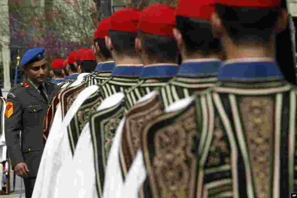 Seorang perwira militer memeriksa pasukan pengawal Presiden Yunani sebelum parade untuk memperingati Hari Kemerdekaan Yunani di ibukota Athena.