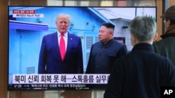 FILE - People watch a TV screen showing a file image of North Korean leader Kim Jong Un and U.S. President Donald Trump, left, during a news program at the Seoul Railway Station in Seoul, South Korea, Dec. 31, 2019.