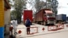 FILE - A Congolese policewoman and customs officials secure the gate barriers at their border crossing point with Rwanda in Goma town in the eastern Democratic Republic of Congo, Aug. 29, 2013. 