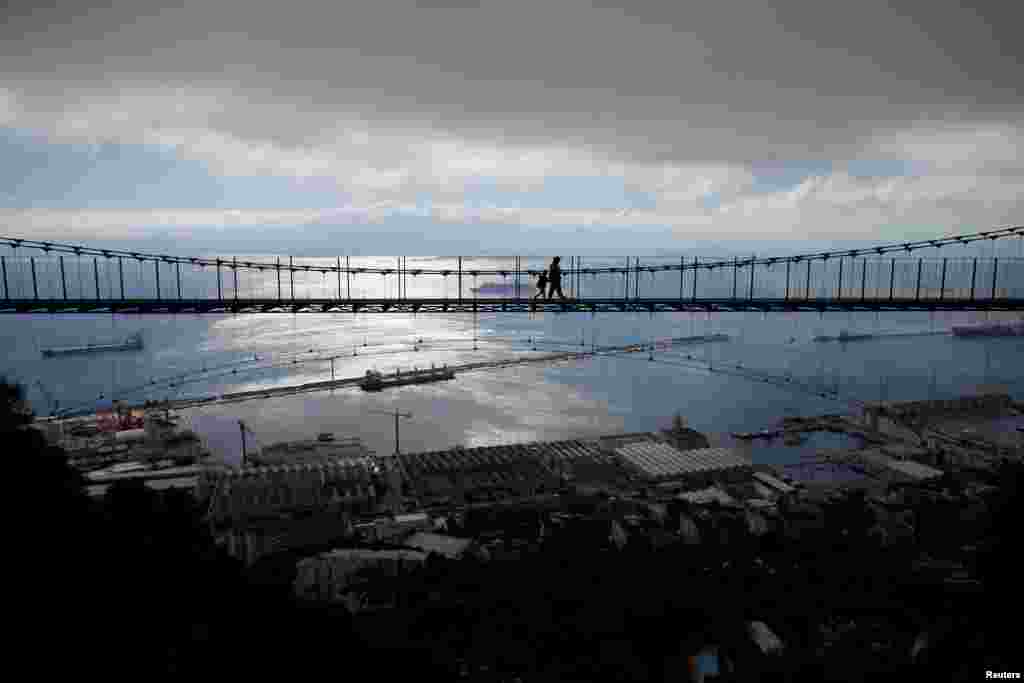 ភ្ញៀវទេសចរ​ដើរកាត់​ស្ពាន Windsor Bridge នៅ​ព្រំដែន​អង់គ្លេស​ក្នុង​ទីក្រុង​ Gibraltar ដែល​ទាមទារ​ដោយ​ប្រទេស​អេស្ប៉ាញ​កាលពិ​ថ្ងៃទី​១៨ មេសា​២០១៨។