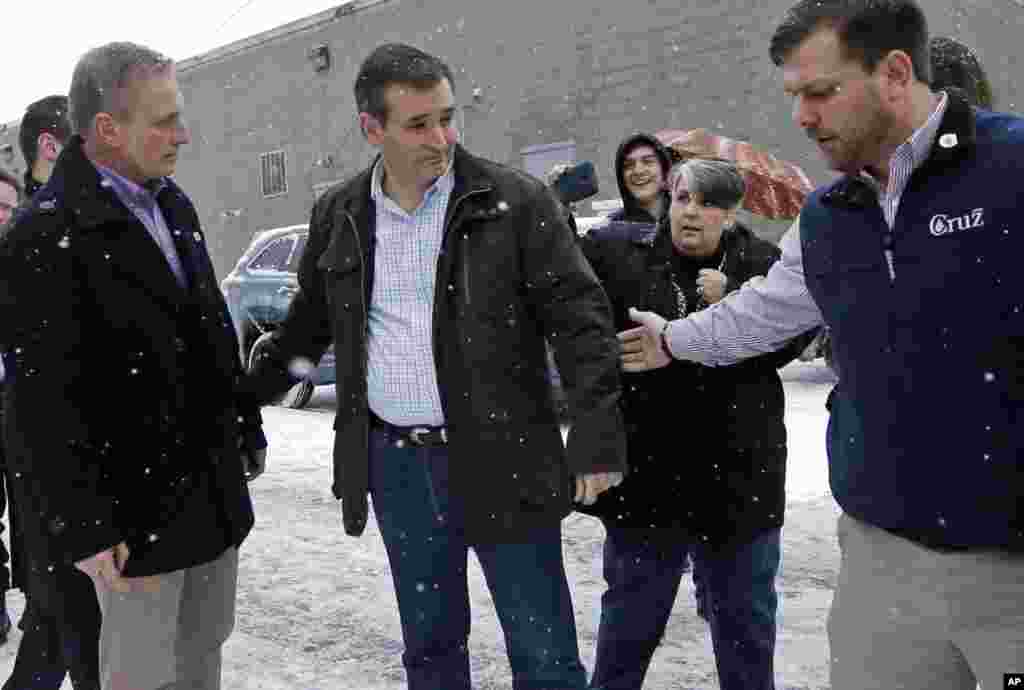Republican presidential candidate, Sen. Ted Cruz, R-Texas, center, walks with aides toward his bus after a campaign event, Feb. 8, 2016, in Manchester, N.H.