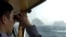 In this April 28, 2005, file photo, a South Korean coast guard looks at Dokdo islets, known as "Takeshima" in Japanese, through a telescope on the patrol ship Sambong-ho on the East Sea, South Korea. 