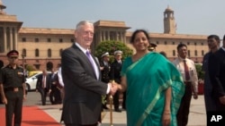 짐 매티스 미국 국방장관(왼쪽)과 니르말라 시타라만 인도 국방장관이 26일 뉴델리 인도 국방부 앞에서 악수하고 있다.