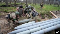 Wanajeshi wa Ukraine wakikusanya makombora ya Russia katika kijiji cha Berezivka, Ukriane, Aprili 21,2022