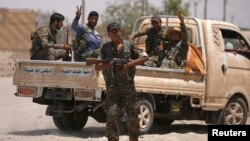 지난 6월 시리아 락까 서부 지역에서 무장한 시리아민주군(SDF) 병사들이 트럭으로 이동하고 있다.