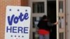 FILE - A polling worker enters a polling place in Charlotte, N.C., April 24, 2019, as early voting began in the Republican primary election for the North Carolina 9th Congressional District, a special election forced by a ballot-collection scandal.