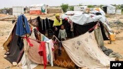 A woman and child sit together in an enclosure made from fabrics at a make-shift camp for displaced Yemenis in the northern Hajjah province, Dec. 16, 2019.
