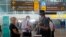Petugas bandara memeriksa warga Australia setibanya di bandara internasional Ngurah Rai, Bali, 18 Agustus 2021. (AP Photo/Firdia Lisnawati)