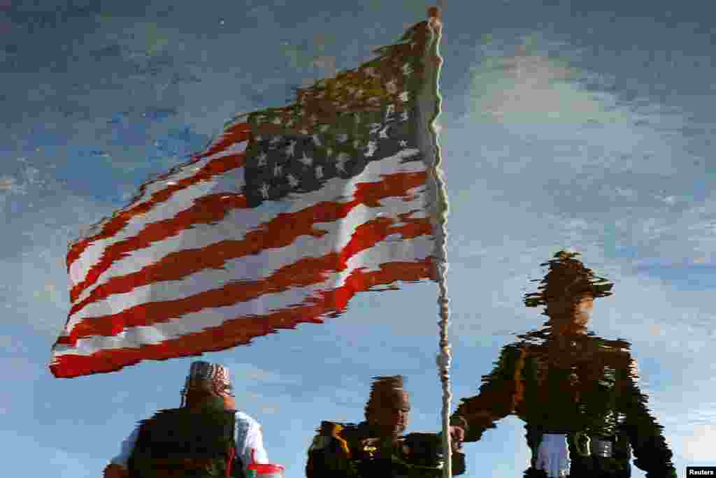 រូប​ឆ្លុះ​នៃ​ក្រុម​មន្រ្តី​មាន​សមត្ថកិច្ច ដែល​បាន​ប្រមូលផ្តុំ​នៅ​ខាង​មុខ​មជ្ឈមណ្ឌល​គ្រឹស្តសាសនា Living Faith មុន​ពេល​ការ​ចាប់​ផ្តើម​ពិធី​បុណ្យ​សព​សម្រាប់​មន្រ្តី​ប៉ូលិស​លោក Montrell Jackson ក្នុង​ក្រុង Baton Rouge រដ្ឋ Louisiana។