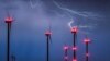 Lightning strikes close to wind turbines in a wind energy park during a thunderstorm near Sieversdorf in eastern Germany.