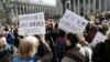 FILE - People hold anti-deportation signs during a rally, March 9, 2017, in New York. The rally was held in support of Ravi Ragbir, leader of the New Sanctuary Coalition, and an immigrant from Trinidad, who may face deportation. 