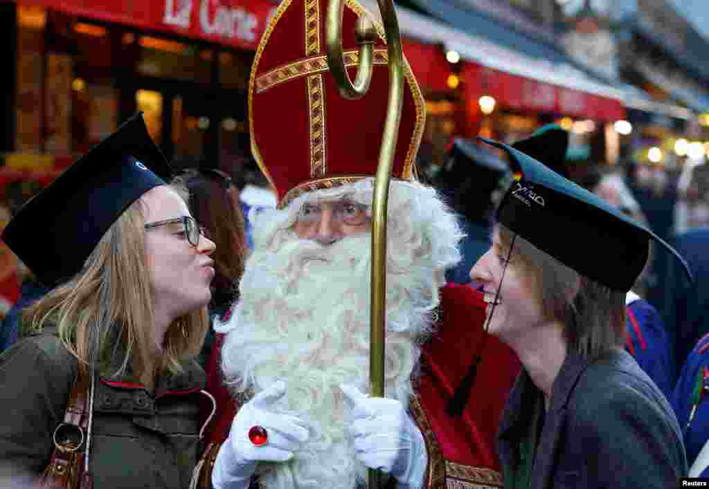 Santa &#39;Nicholas&#39; berpose dengan para pelajar pada parade tradisional menyambut Natal di Brussels, Belgia.