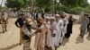 A Pakistani paramilitary soldier checks voters before they enter a polling station to cast their ballots, in Karachi, Pakistan, May 11, 2013.