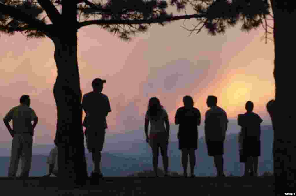 Warga setempat menonton gumpalan asap raksasa dari Waldo Canyon, sebelah barat Colorado Springs saat matahari terbenam.