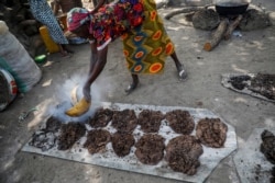 FILE - Ladi Kodi, a monthly beneficiary of the government's cash transfer program, works to make black soap in Garaku, Nigeria, March 27, 2019.