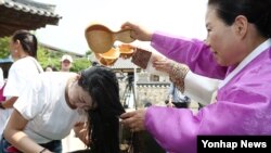 서울 시가 중국여행사총사유한공사(CTS)와 공동 개발한 '서울단오' 상품으로 입국한 중국관광객이 9일 서울 남산골한옥마을에서 창포물로 머리를 감고 있다.