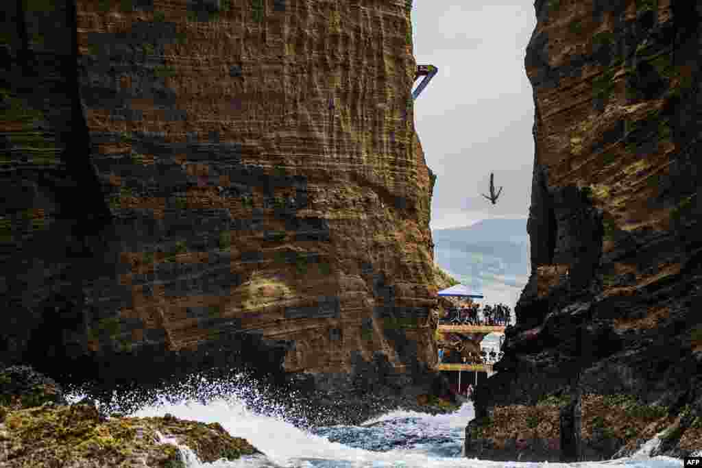 This handout photo received from Red Bull shows Jonathan Paredes of Mexico diving from the 27-meter platform during the fifth stop of the Red Bull Cliff Diving World Series at Islet Franco do Campo, Azores, Portugal, July 18, 2015. Gary Hunt of the UK won his fifth straight event of the year to take a commanding lead in the series.