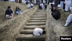 A man prepares graves for the burial of victims of Saturday's bomb attack in a Shi'ite Muslim area, in the Pakistani city of Quetta, February 17, 2013.