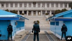 资料照：在朝韩军事分界线板门店的两国士兵在对视。（2014年3月12日）
