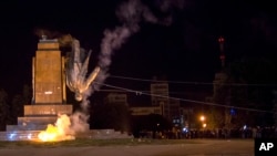 Para aktivis menggulingkan monumen Lenin terbesar di Ukraina dalam demonstrasi pro-Ukraina di Kharkiv (28/9). (AP/Igor Chekachkov)