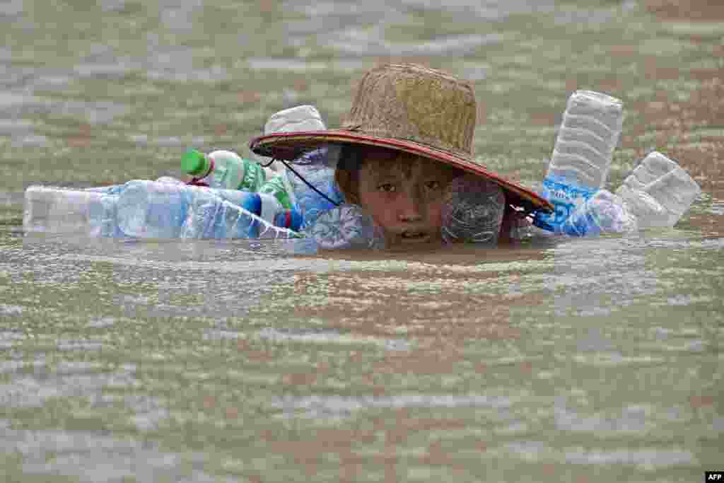 A flood-affected resident swims in floodwaters at Kyaut Ye village near the Hinthada town in Myanmar&#39;s Irrawaddy region, Aug. 11, 2015.