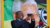 Cyril Ramaphosa utilise son téléphone lors d'un rassemblement pour commémorer l'année du centenaire de Nelson Mandela au Cap, en Afrique du Sud, le 11 février 2018.