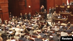 Displaced Afghans wait for aid near the site of a landslide at the Argo district in Badakhshan province.