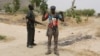 FILE - Members of a civilian vigilante group stand guard at the border with Nigeria in Kerawa, Cameroon, March 16, 2016. Kerawa is on the border with Nigeria and is subject to frequent Boko Haram attacks. 