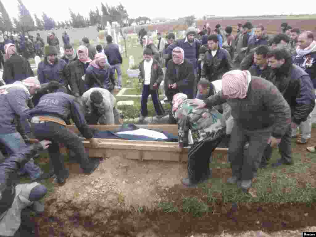 叙利亚自由军的战士和死者的亲属1月29日在霍姆斯附近掩埋活动人士称被忠于叙利亚总统阿萨德的部队杀害的人(沙姆新闻网)