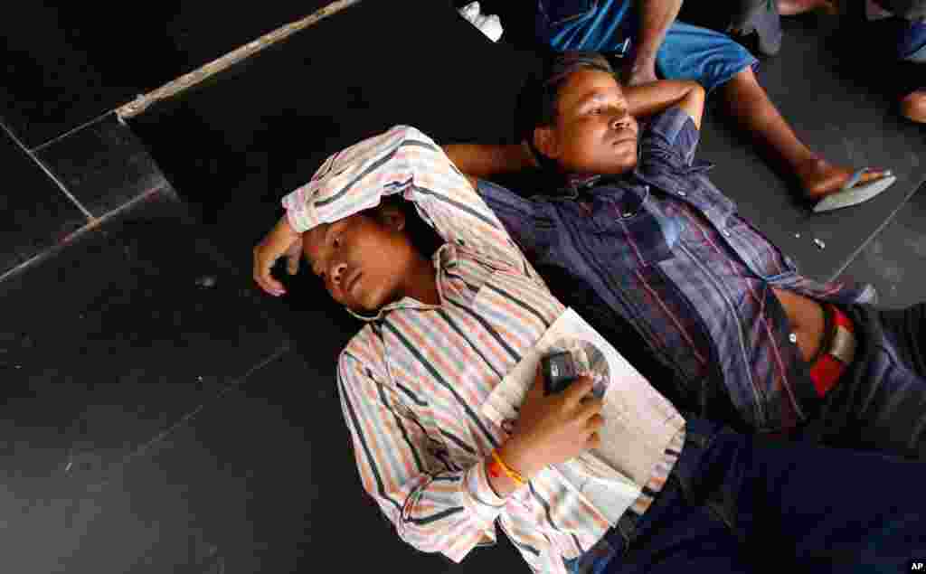 Men from India's northeastern states rest outside the train station in Bangalore.