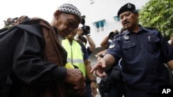 Polisi mengecek identitas seorang pria di Kuala Lumpur, Malaysia. (AP/Lai Seng Sin)