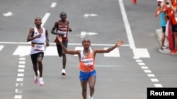 FILE - Abdi Nageeye of the Netherlands crosses the finish line to win silver, with Belgium's Bashir Abdi, left, coming in third and Kenya's Lawrence Cherono placing fourth, in the men's marathon at the 2020 Olympics, in Sapporo, Japan, Aug. 8, 2021. 