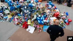 Un policier se recueille devant un mémorial improvisé au siège de la police de Dallas, le 11 juillet 2016.