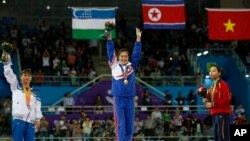 24일 인천아시아경기대회 여자 기계체조 도마에서 금메달을 딴 북한의 홍은정 선수가 시상식에서 환호하고 있다.