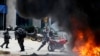 委内瑞拉的加拉加斯的警察在和反政府示威者的冲突里把一辆私人拥有的摩托车推入爆炸引起的火焰中（2017年7月30日）