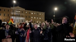 Pripadnici LGBTQ zajednice u Grčkoj i njihovi prijatelji slave ispred zgrade parlamenta u Atini posle usvajanja predloga zakona o istopolninm brakovima, 15. februara 2024. (Foto: REUTERS/Louisa Gouliamaki)
