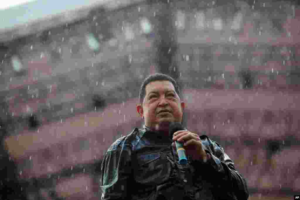 Hugo Chavez memegang mikrofon dalam hujan saat menutup kampanye di Caracas, 4 Oktober 2012.