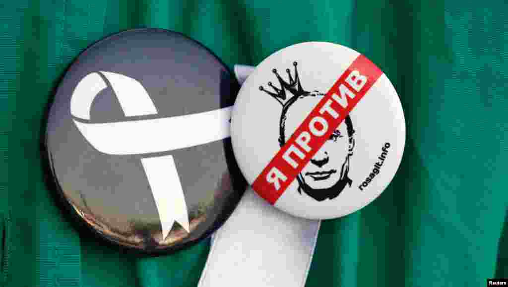 The badge on the right reads, &quot;I&#39;m against&quot;. The badge on the left is the symbol for the protest movement.