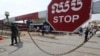 Local police officers stand guard at a blocked street near Phnom Penh International airport in Phnom Penh, Cambodia, Thursday, April 15, 2021. (AP Photo/Heng Sinith)